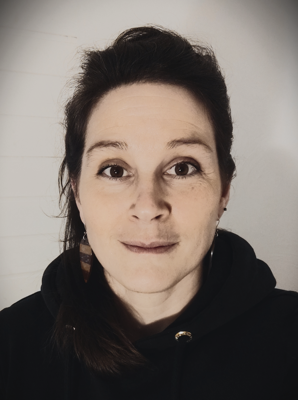 Photo noir et blanc de la céramiste potière de l'atelier Terre de Djen . 
Portrait souriant.