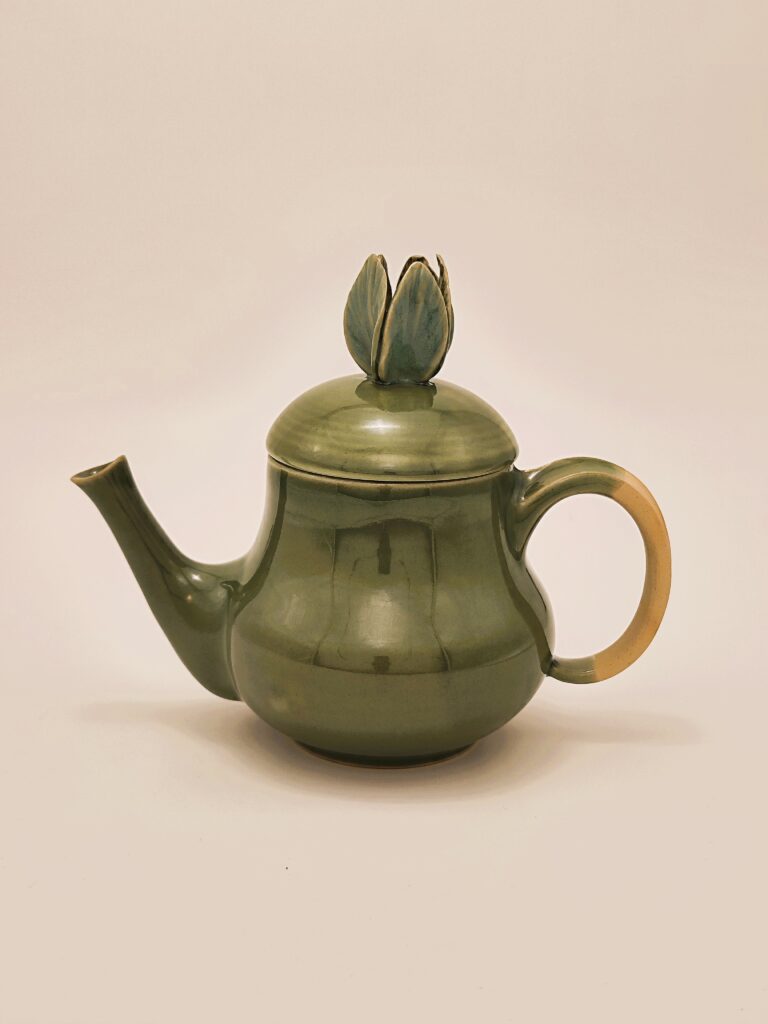 théière en forme de bouton de fleurs ansé sur le coté avec une éclosion de bouton sur le couvercle, émaillé vert céladon jusqu'à la moitié de la anse.
Atelier terre de Djen